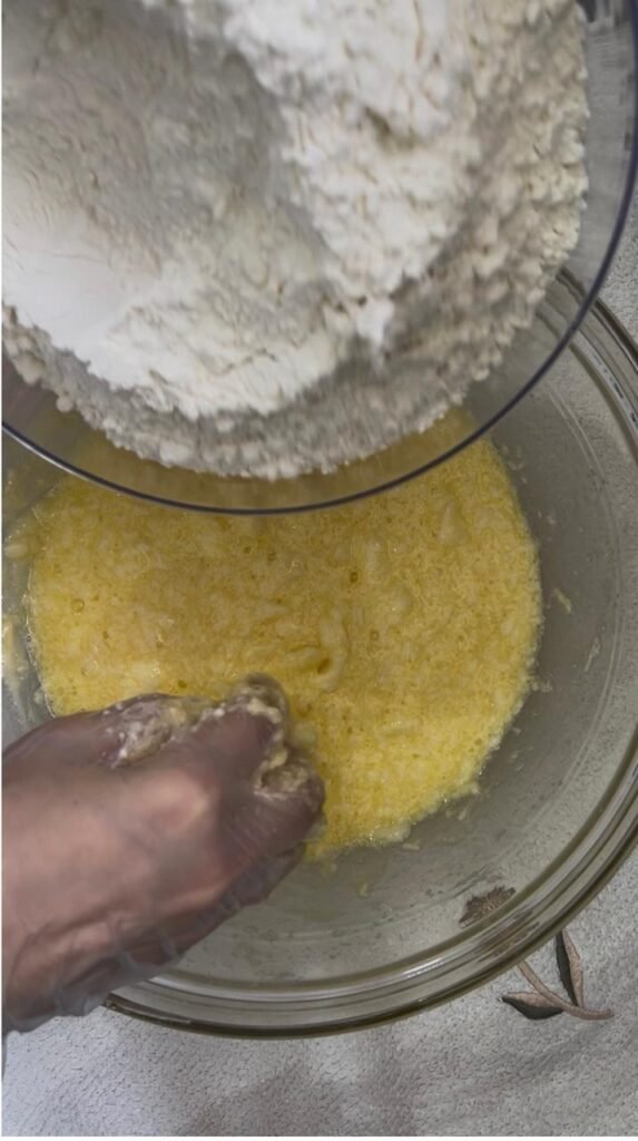 Flour poured into the wet mixture for chocolate walnut cookies