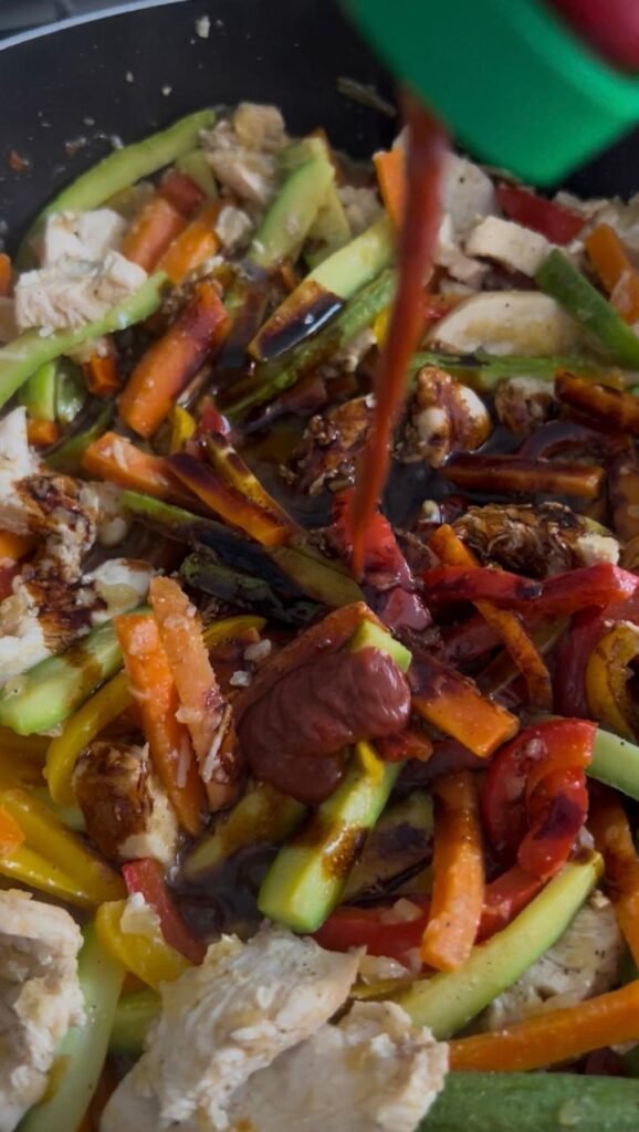 Adding a splash of hot sauce to the stir fry
