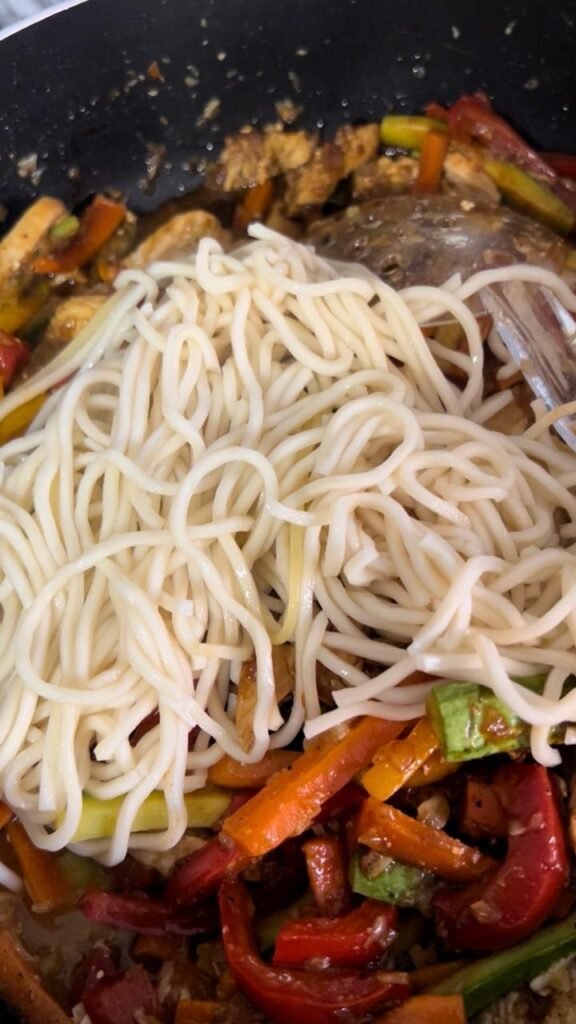 Cooked noodles added to the chicken and vegetables