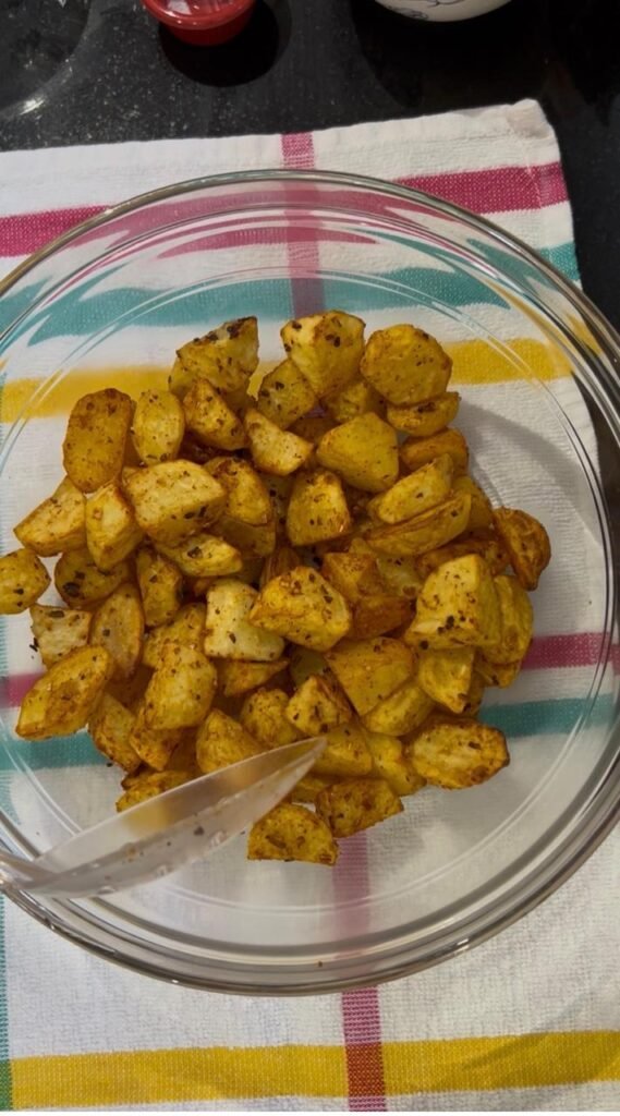 Golden crisp air fried potato cubes in a glass bowl