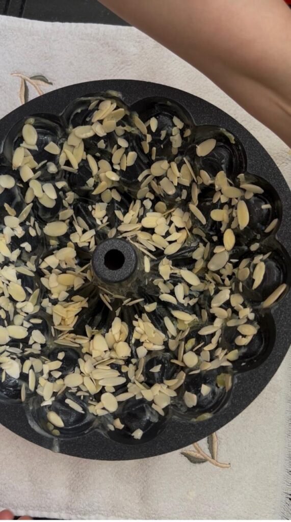 Almond flakes layered in the bottom of a Bundt pan