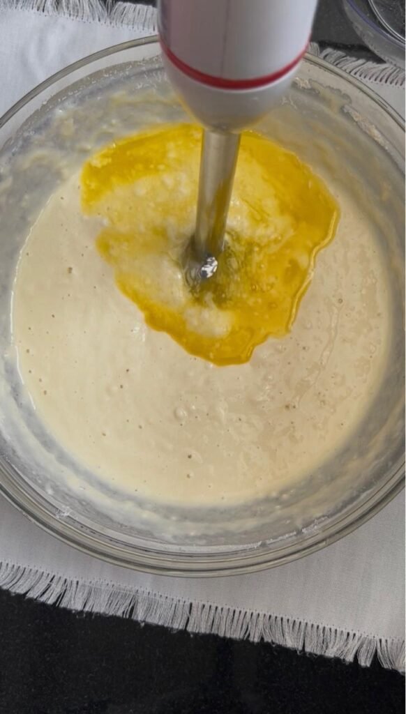 Immersion blender mixing buttermilk crepe batter with melted butter