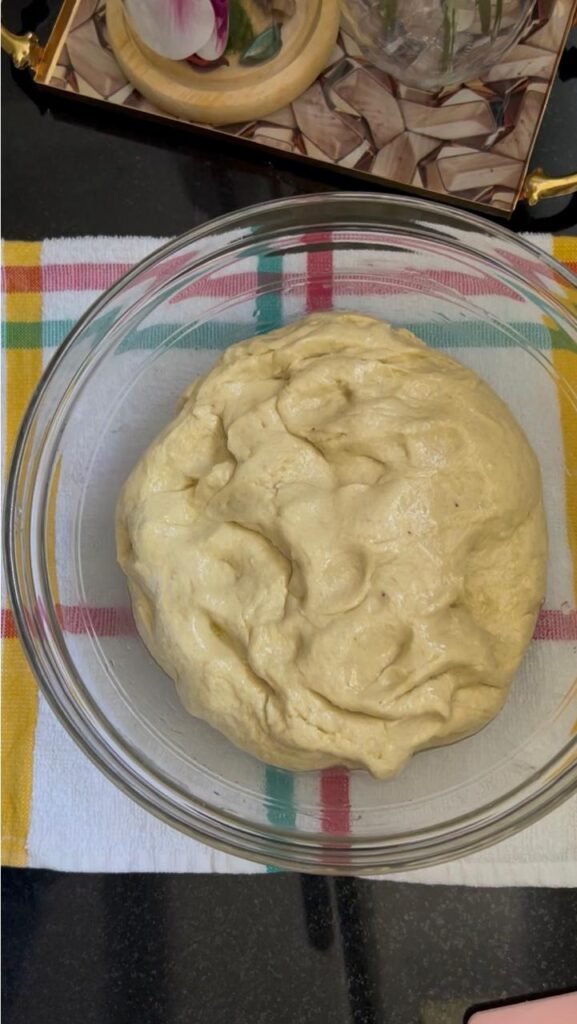 Smooth banana dough in a glass bowl before the first rise