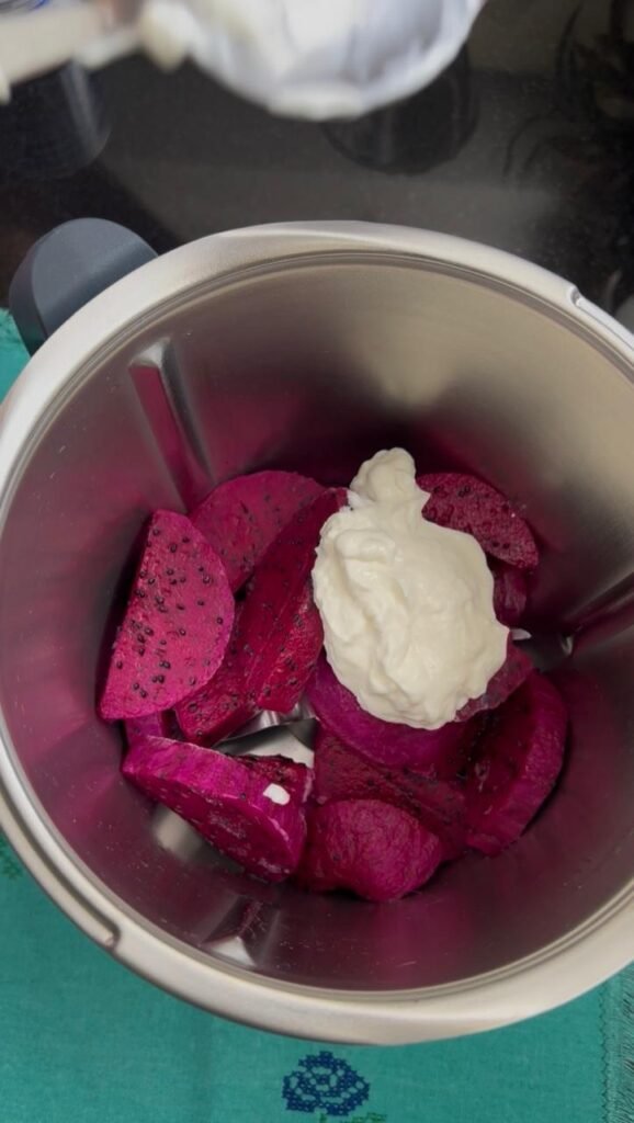 Dragon fruit pieces topped with plain yogurt in a blender bowl