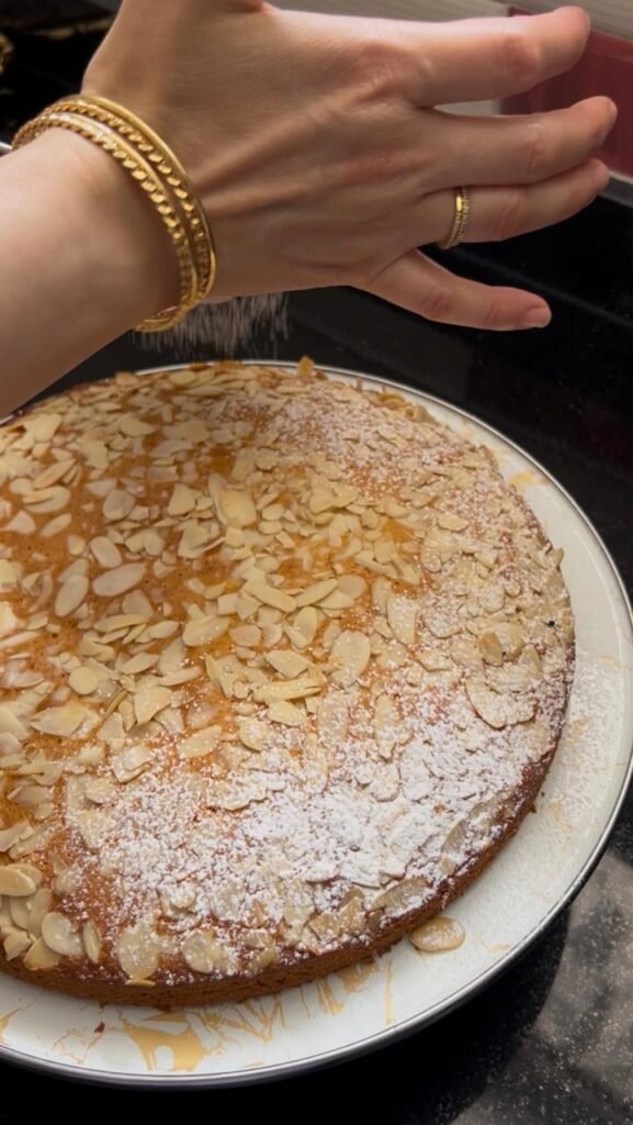 Dusting powdered sugar over the fully cooled cake