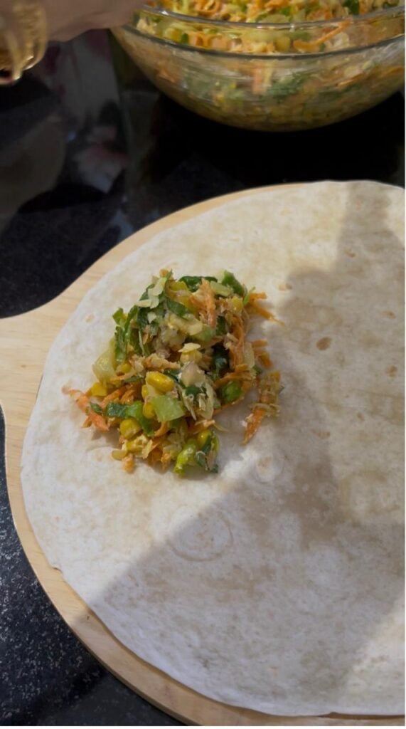 Tuna filling placed off-center on a flour tortilla before rolling
