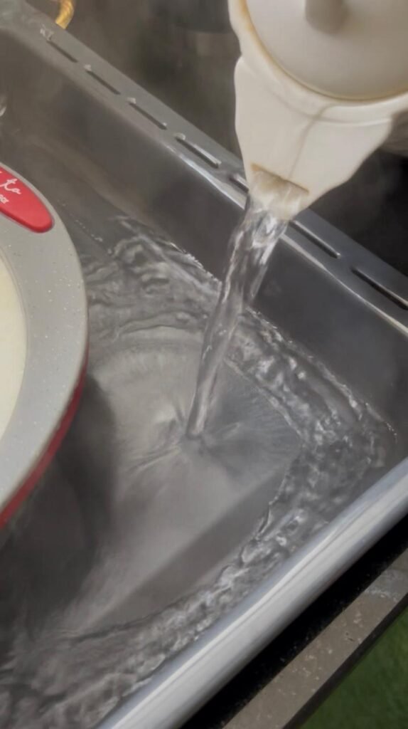 Placing the flan dish in a hot water bath before baking