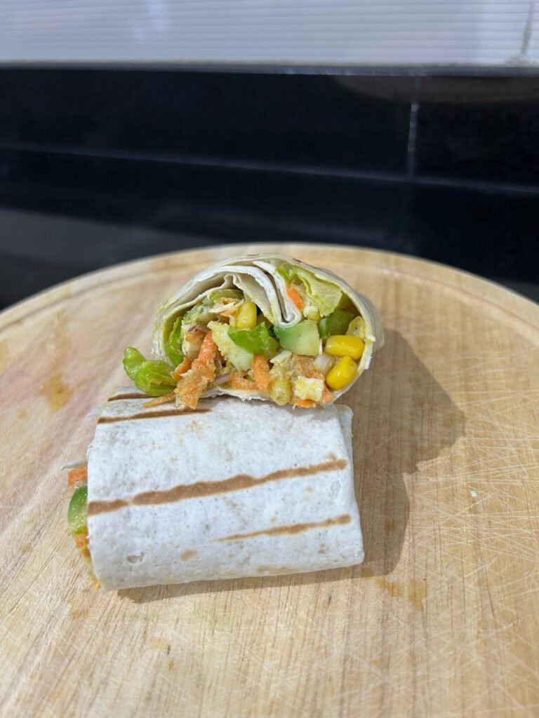 Grilled tuna wrap sliced in half showing avocado, corn and carrot filling
