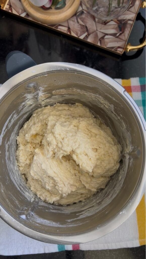 Banana roll dough gathered and kneaded in a stand mixer bowl