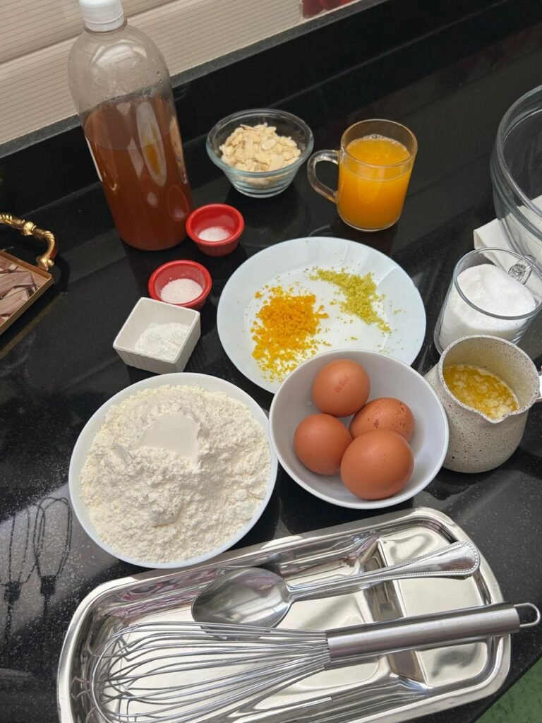 Ingredients for orange almond cake: eggs, flour, orange juice, orange and lemon zest, melted butter and sliced almonds