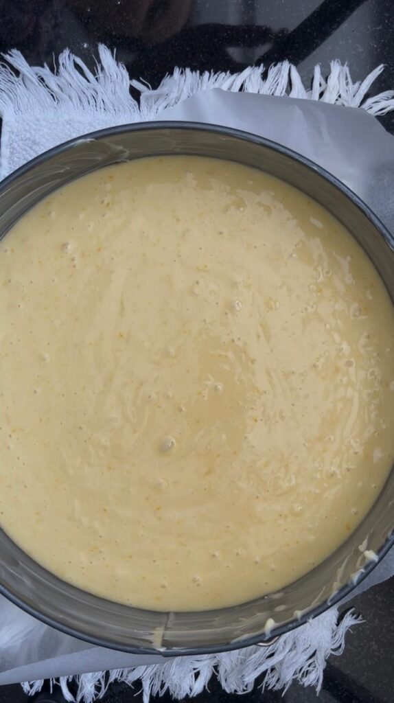 Orange cake batter poured into the prepared pan