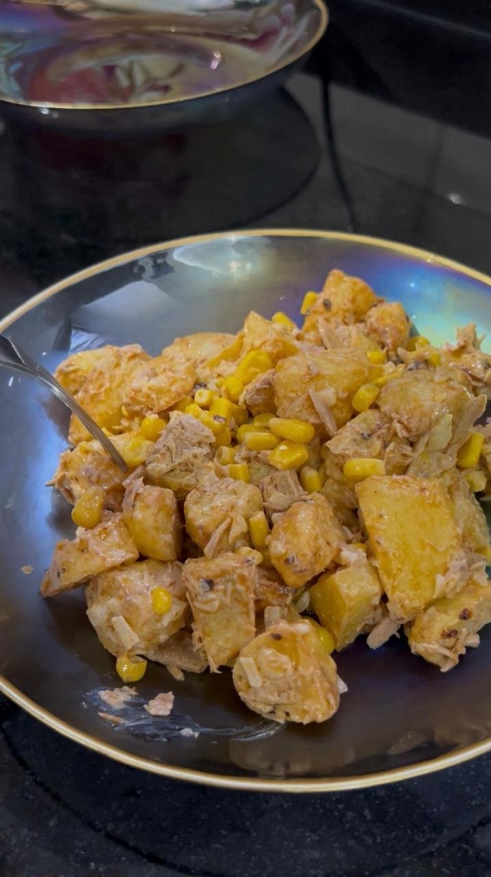 Air fryer potato salad with tuna, corn and yogurt dressing in a dark serving bowl