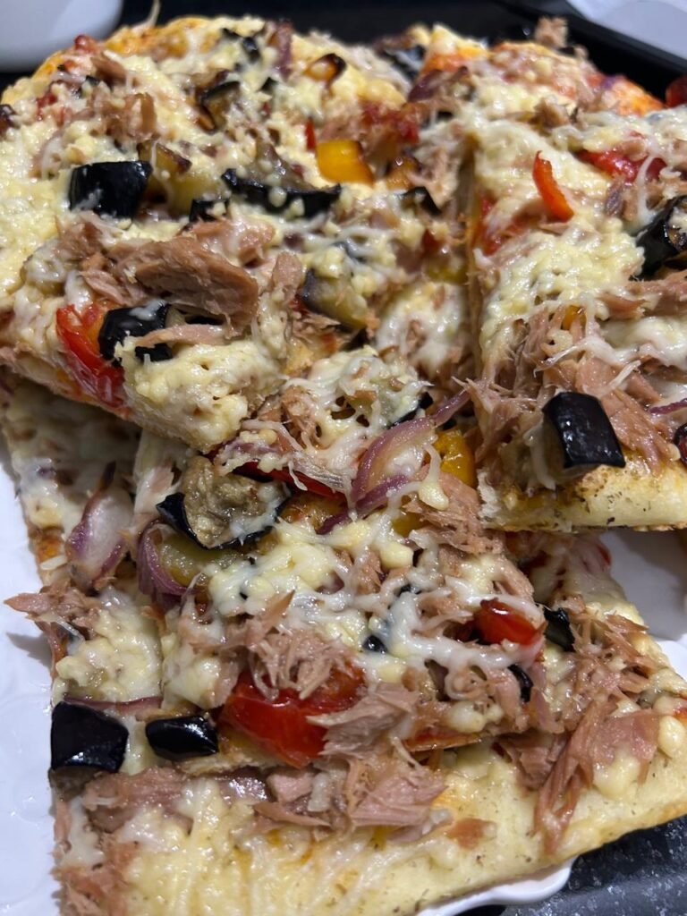 Slices of high protein veggie pizza with tuna and melted cheese