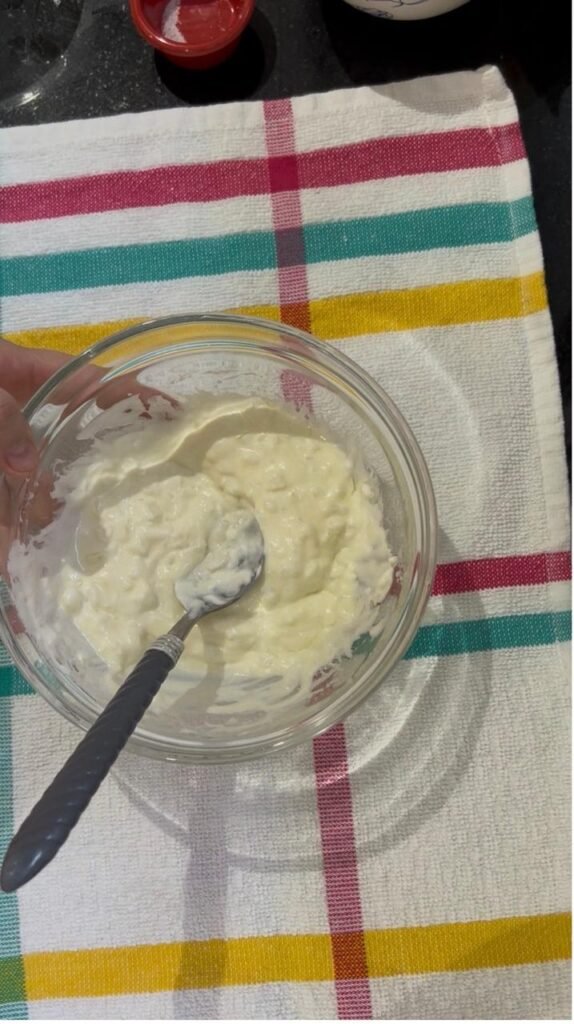 Plain yogurt dressing mixed in a small glass bowl