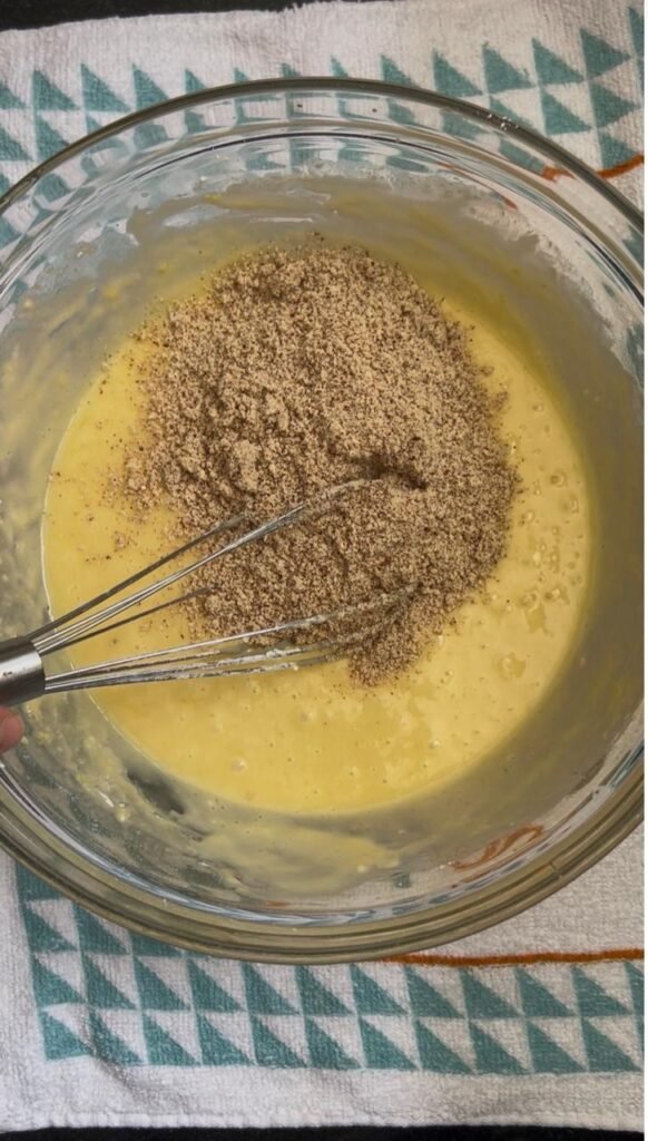 Sifting flour and almond flour into the cake batter