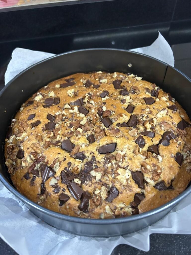 Fully baked easy banana chocolate cake in baking pan, golden brown with toppings