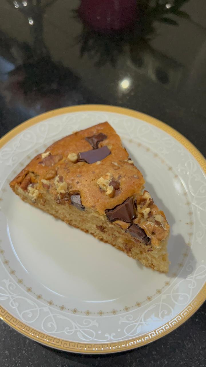 Easy banana chocolate cake slice showing moist crumb, walnuts and dark chocolate chunks