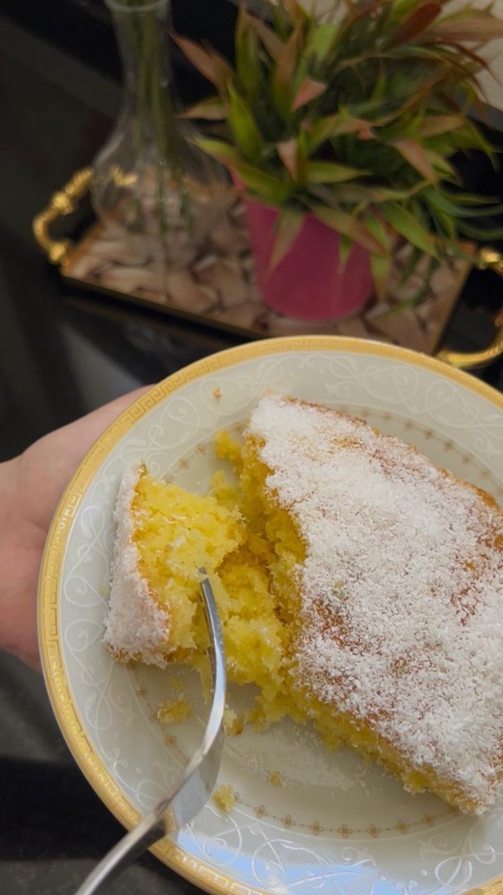 Easy orange basbousa cake slice on plate with powdered sugar showing tender moist crumb and syrup soak