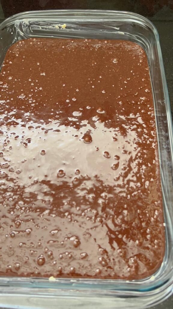 Fudgy brownie batter poured into a glass baking dish