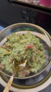 Easy homemade guacamole in a bowl with fresh parsley, showing creamy texture made with fork