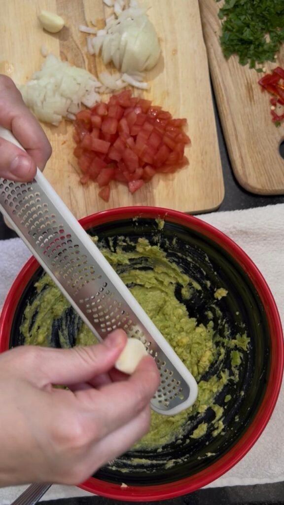 Mashing ripe avocado with fork to achieve creamy texture for homemade guacamole