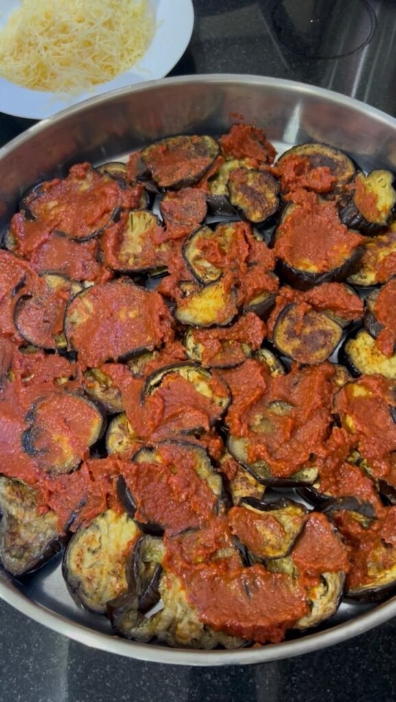 Roasted eggplant rounds topped with tomato sauce for make-ahead moussaka layering
