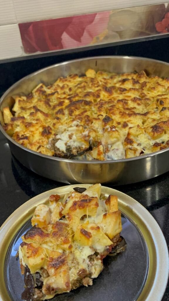 Close-up of moussaka slice showing distinct layers: eggplant, meat, potato, béchamel