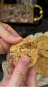 Nut and seed shortbread cookie broken open showing walnuts and hazelnuts