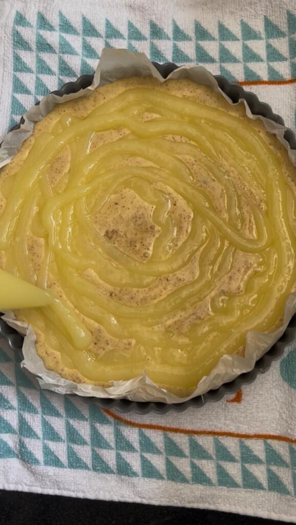 Lemon curd piped in a spiral over almond cake batter