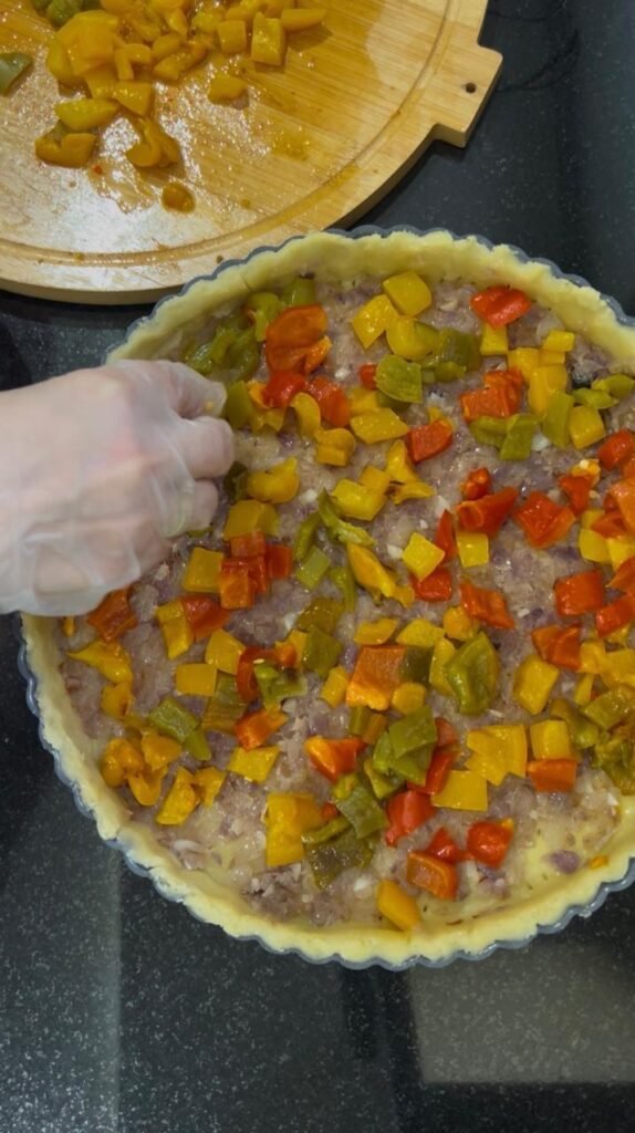 Roasted red, yellow and green peppers layered in a quiche crust