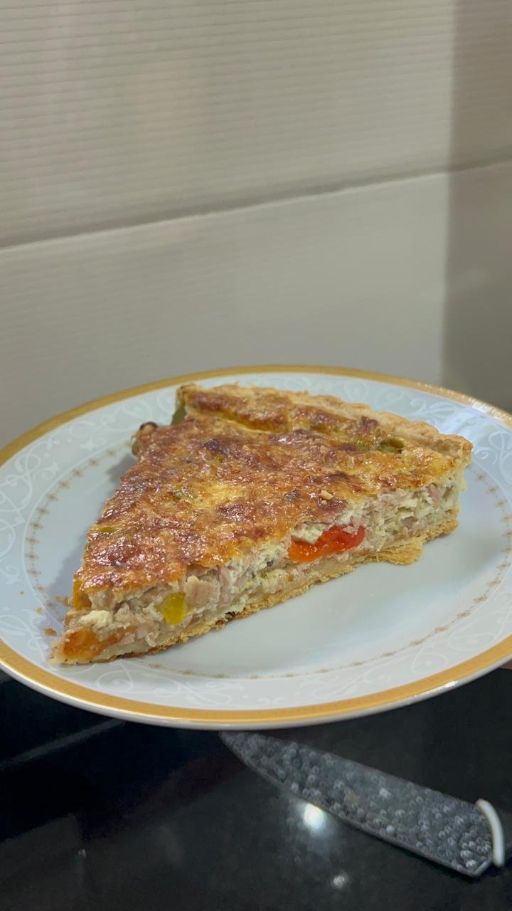 Slice of tuna and pepper quiche showing tuna, roasted peppers and custard filling