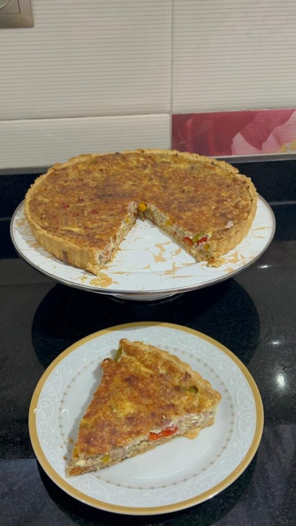 Whole tuna and pepper quiche with a slice served on a plate