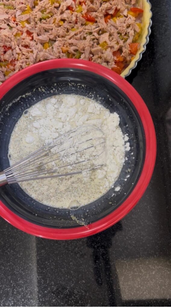 Whisking milk, cream, eggs and cornstarch into smooth quiche custard