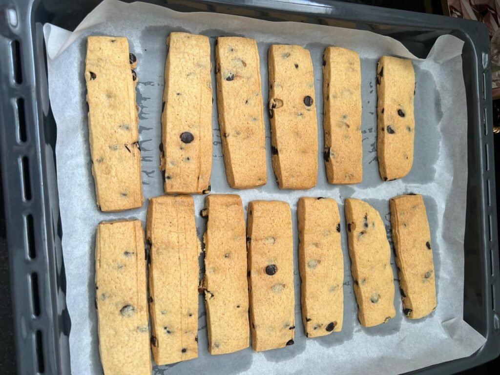 Golden-brown easy chocolate chip cookie bars fresh from oven on parchment-lined baking sheet