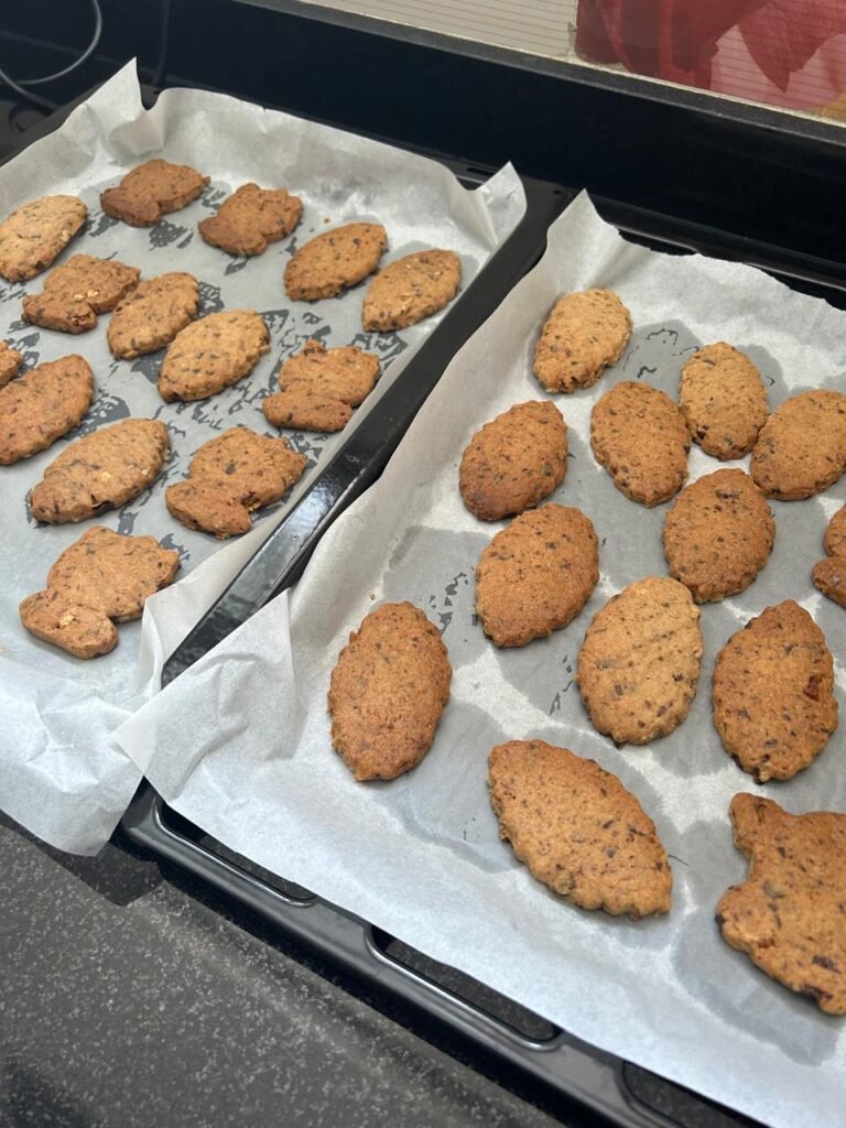 Chocolate walnut sablé cookies cooling on baking sheet before transfer to cooling rack