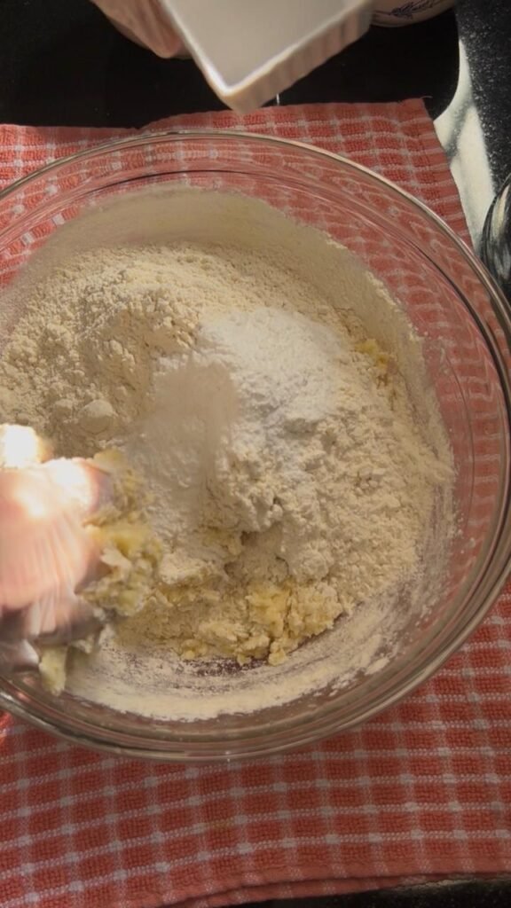 Flour and salt folded into butter, sugar, and egg mixture for chocolate walnut sablé cookies