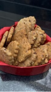 Chocolate walnut sablé cookies stacked on white plate showing delicate shapes and golden color