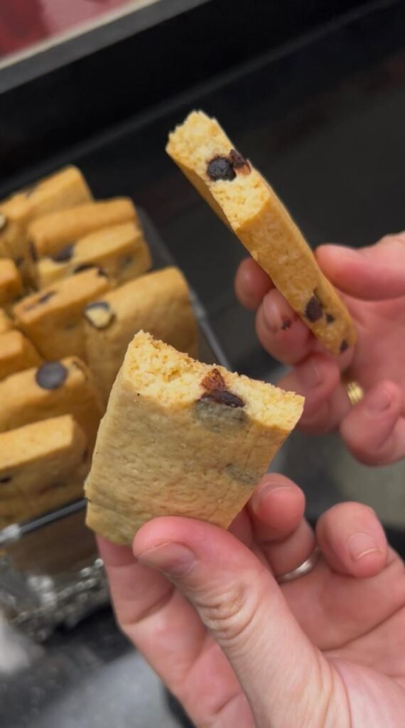 Single easy chocolate chip cookie bar held in hand showing crispy exterior and tender center
