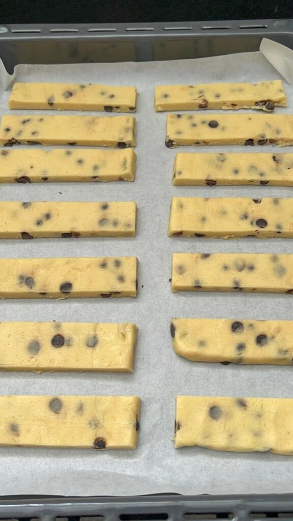 Cookie bar dough slab shaped on parchment paper ready for freezer, showing thickness and edges