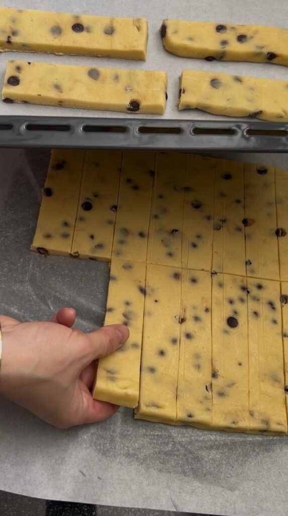 Chilled cookie bar dough sliced into neat rectangular bars with chocolate chips visible