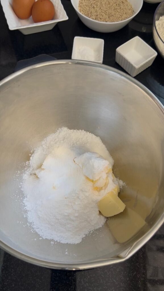 Soft butter, powdered sugar, and vanilla sugar creamed together until pale and fluffy for golden almond sablé cookies