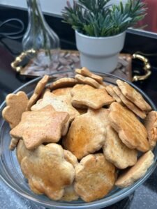 Golden almond sablé cookies styled with white ceramic bowl and fresh rosemary, showing elegant presentation