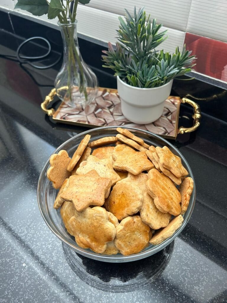 Golden almond sablé cookies arranged in decorative display with gold tray and potted plant, elegant styling
