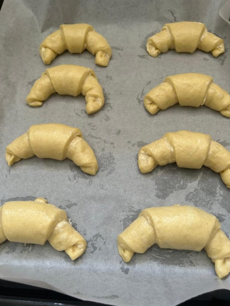 Shaped crescent rolls risen to double volume during final proof for homemade crescent rolls