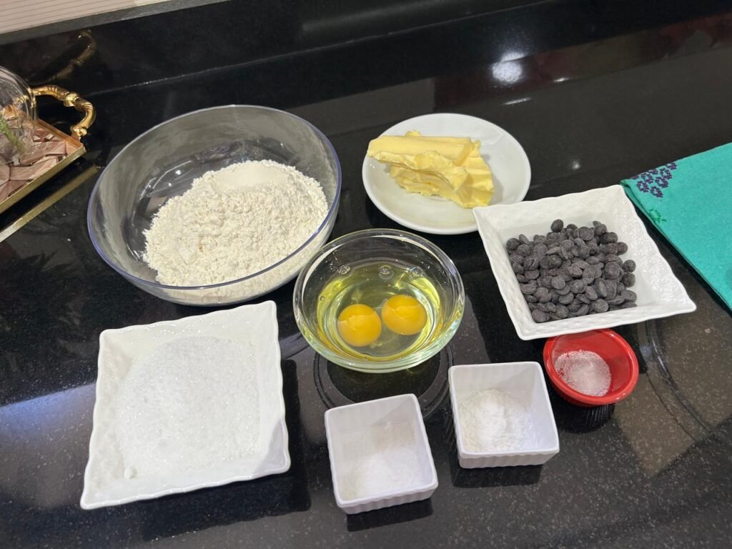Easy chocolate chip cookie bars ingredients laid out: butter, sugar, eggs, flour, baking powder, chocolate chips