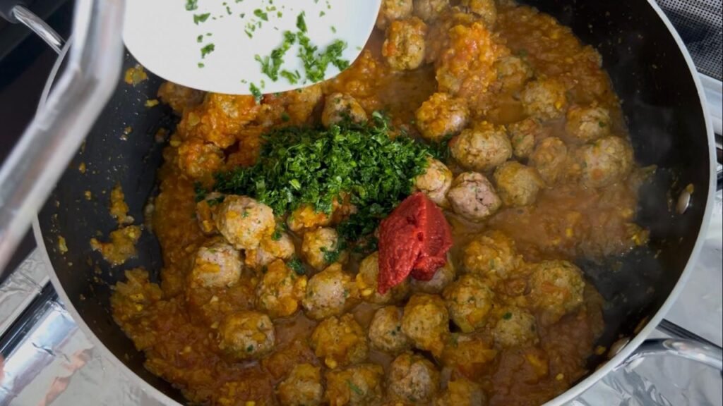 Meatballs simmering in spiced sauce for easy meatball and potato stew