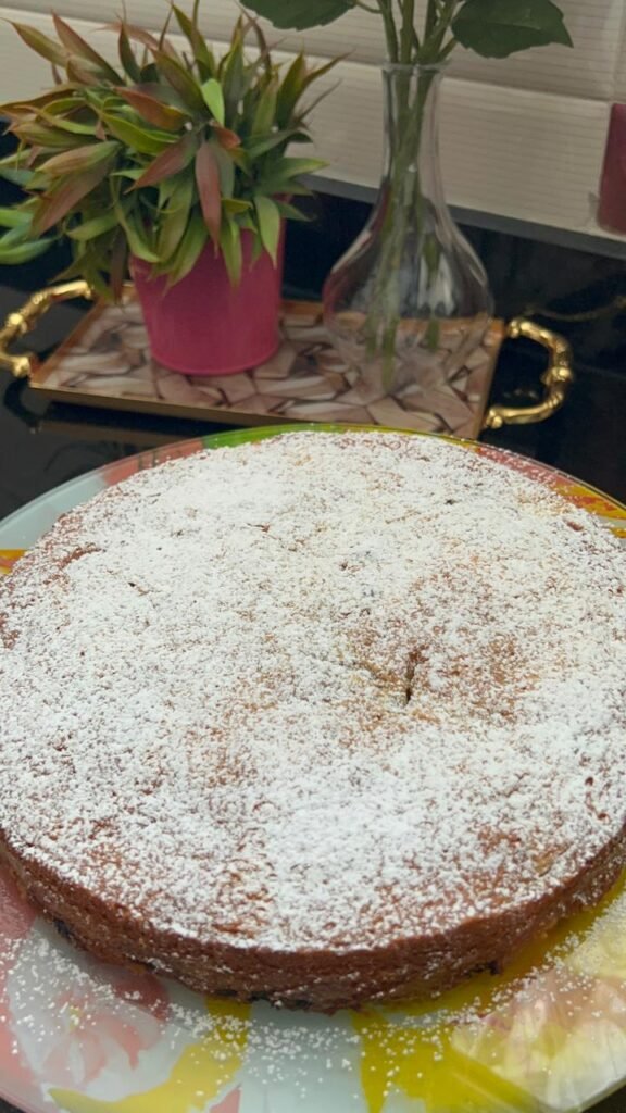Cooled easy peach cake with visible peaches and chocolate on top surface