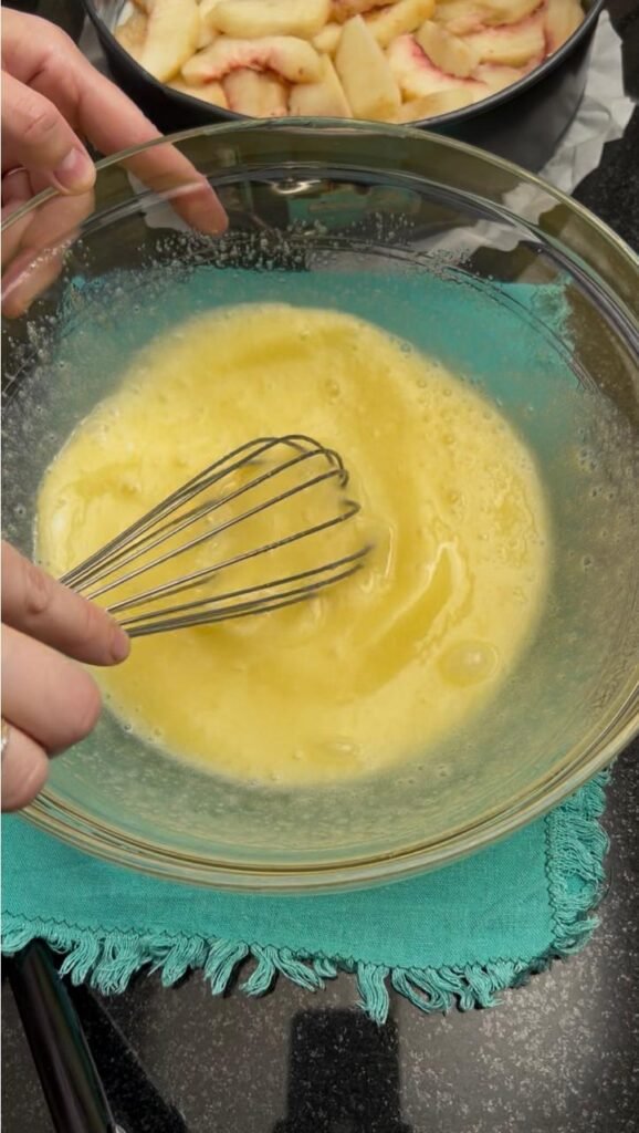 Eggs and sugar whisked pale and frothy for easy peach cake batter